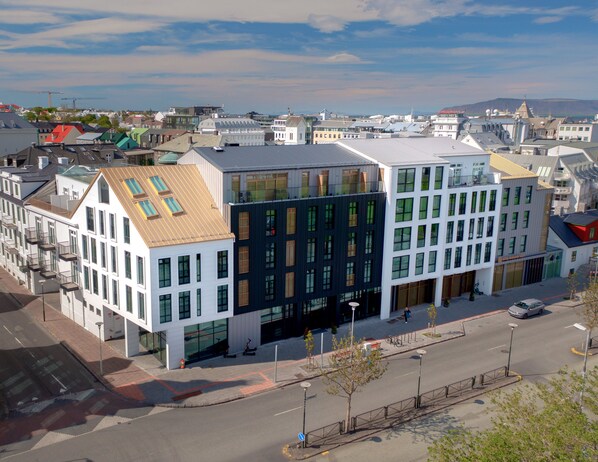 A modern building with a flat roof, large windows, and a prominent entrance. - Hotel Reykjavik Saga (Reykjavik)