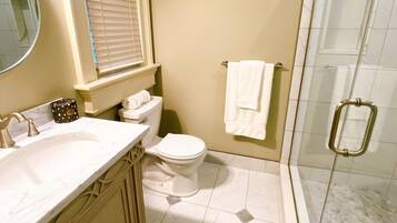 Un baño con inodoro, lavamanos y ducha.