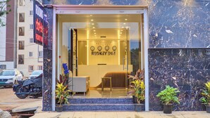 Ingresso di un hotel con reception, orologio e cartello che riporta 'REDKEY INN'.