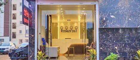 A hotel entrance with a reception desk, a clock, and a sign that reads 'REDKEY INN.'