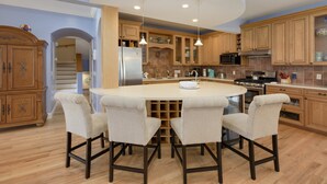 Una cocina moderna con una isla central, armarios de madera y un microondas integrado.
