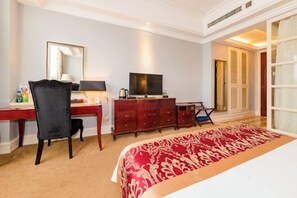 A hotel room with a bed, a desk with a chair, a television, a dresser, and a large window. - Shengfei International Hotel (Pingyu)
