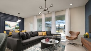 A modern living room with a sectional sofa, a round coffee table, and a dining area with yellow chairs. - Barbecue in Summer Kitchen, Smart TV by the Pool! (Davenport)