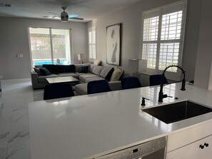 Relax in this stylish living area with a large kitchen island, comfortable sofa, and a unique art piece.