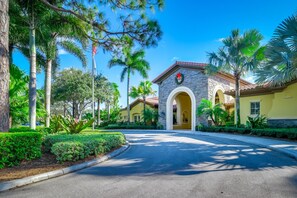 Stunning Mediterranean-style building with a welcoming arched entrance and lush tropical surroundings.