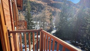 Un pontile in legno con vista su un paesaggio montuoso e un lago.