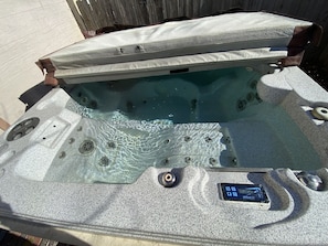 A hot tub with a control panel and a wooden deck in the background. - Luxury Cottage in Nelsonville, close to Train, Opera House, near Hocking Hills (Nelsonville)