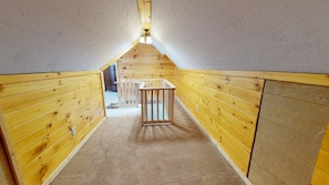 Ein schmaler Holzkorridor mit hoher Decke und einer kleinen Holzkonstruktion in der Mitte.