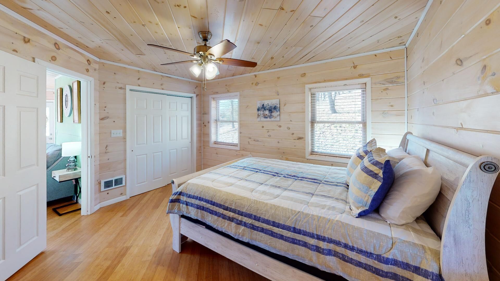 Une chambre à coucher avec un lit, un ventilateur de plafond et une fenêtre.
