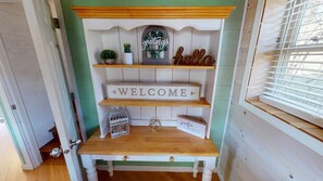 A wooden shelf unit with a 'WELCOME' sign, a 'hello' sign, and a small potted plant. - Luxury Cottage in Nelsonville, close to Train, Opera House, near Hocking Hills (Nelsonville)