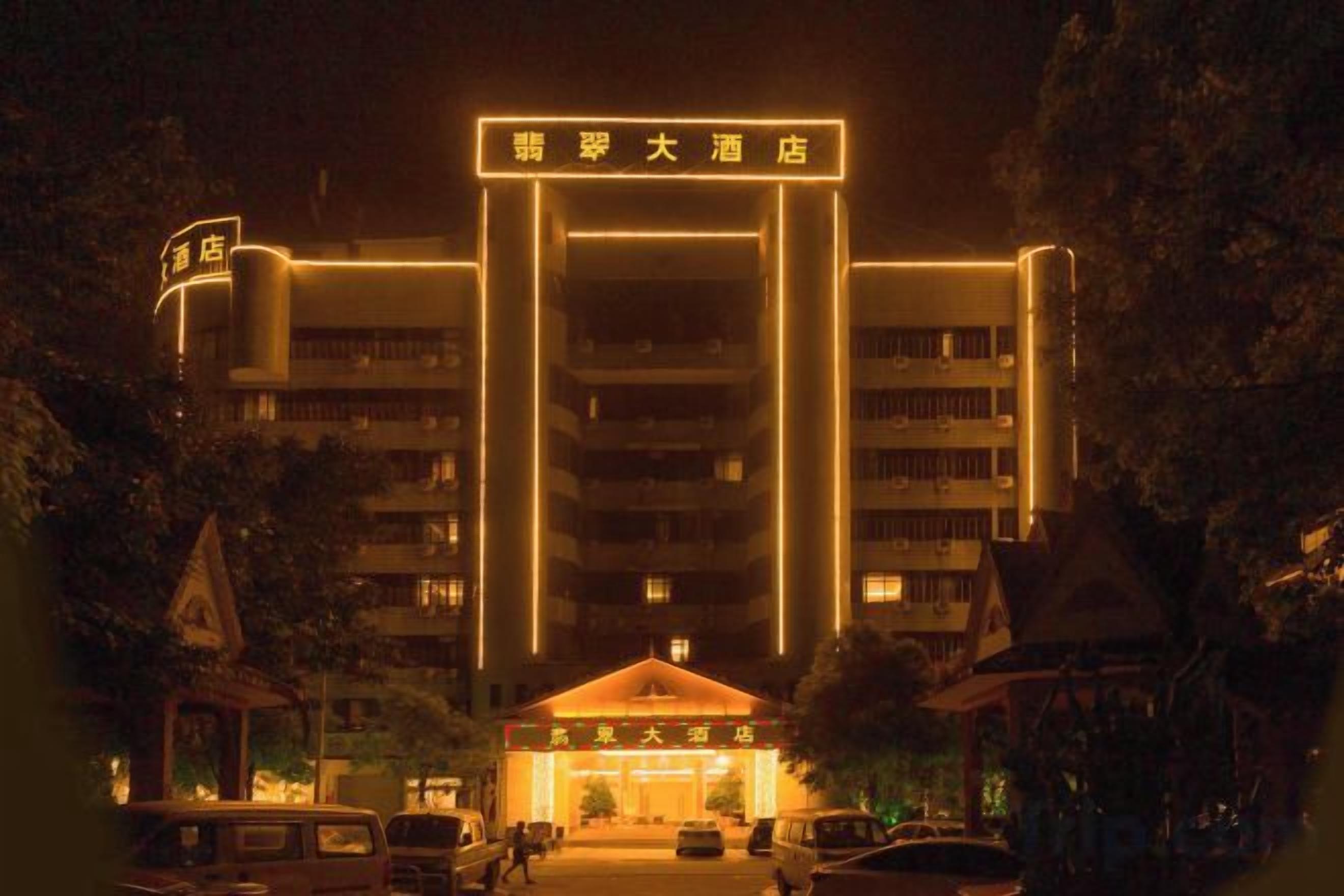 A multi-story hotel with a prominent entrance and illuminated signage.