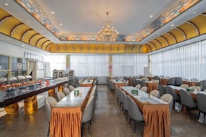 A conference room with a long table, multiple chairs, and a chandelier. - Feicui Hotel (Mangshi)