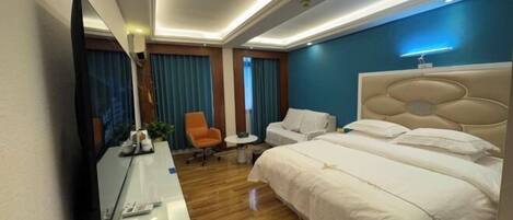 Habitación de hotel con una cama grande, un escritorio con espejo, una silla y una mesita.