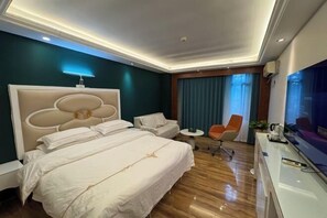 Una habitación de hotel con una cama grande, un escritorio, una silla y un televisor.