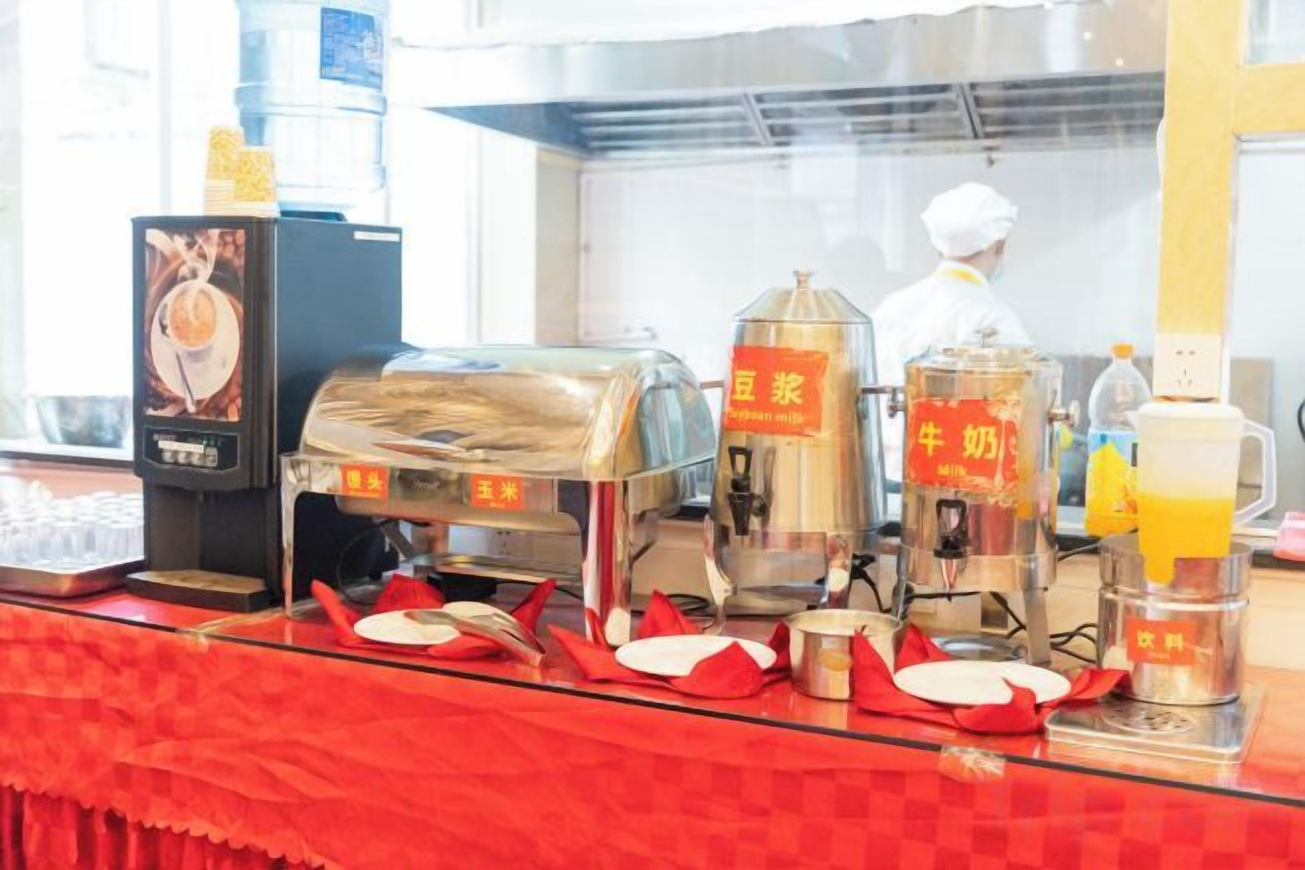 A food service counter with a coffee machine, a milk dispenser, and a beverage dispenser.
