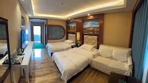 A hotel room with two beds, a sofa, a desk with a tray of toiletries, and a painting on the wall. - Feicui Hotel (Mangshi)