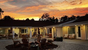 A motel with a gravel patio, outdoor seating, and a sunset view. - River Rock Inn B&B - Adults Only (Green River)
