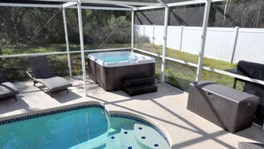 Ein Garten mit Swimmingpool, Whirlpool und Gartenmöbeln.