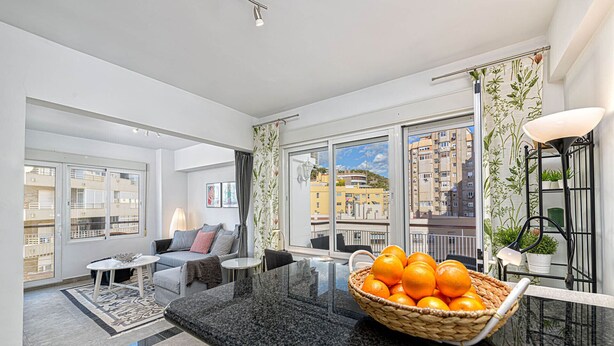 Un apartamento moderno con sala de estar, cocina y balcón.
