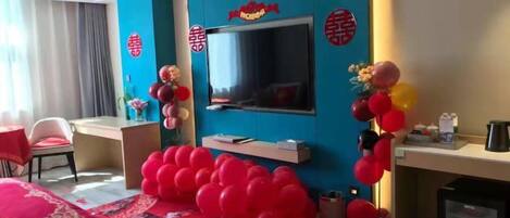 Habitación de hotel con televisión de pantalla plana, escritorio y sofá.