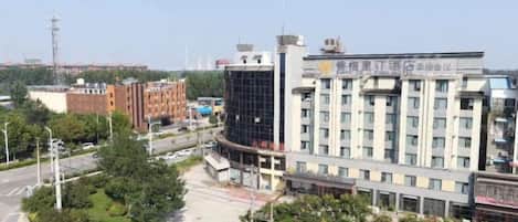 A multi-story building with a modern architectural design, featuring a prominent glass facade and a central entrance.
