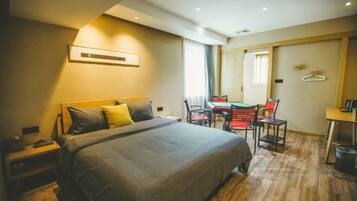 A hotel room with a large bed, a desk, and a chair.