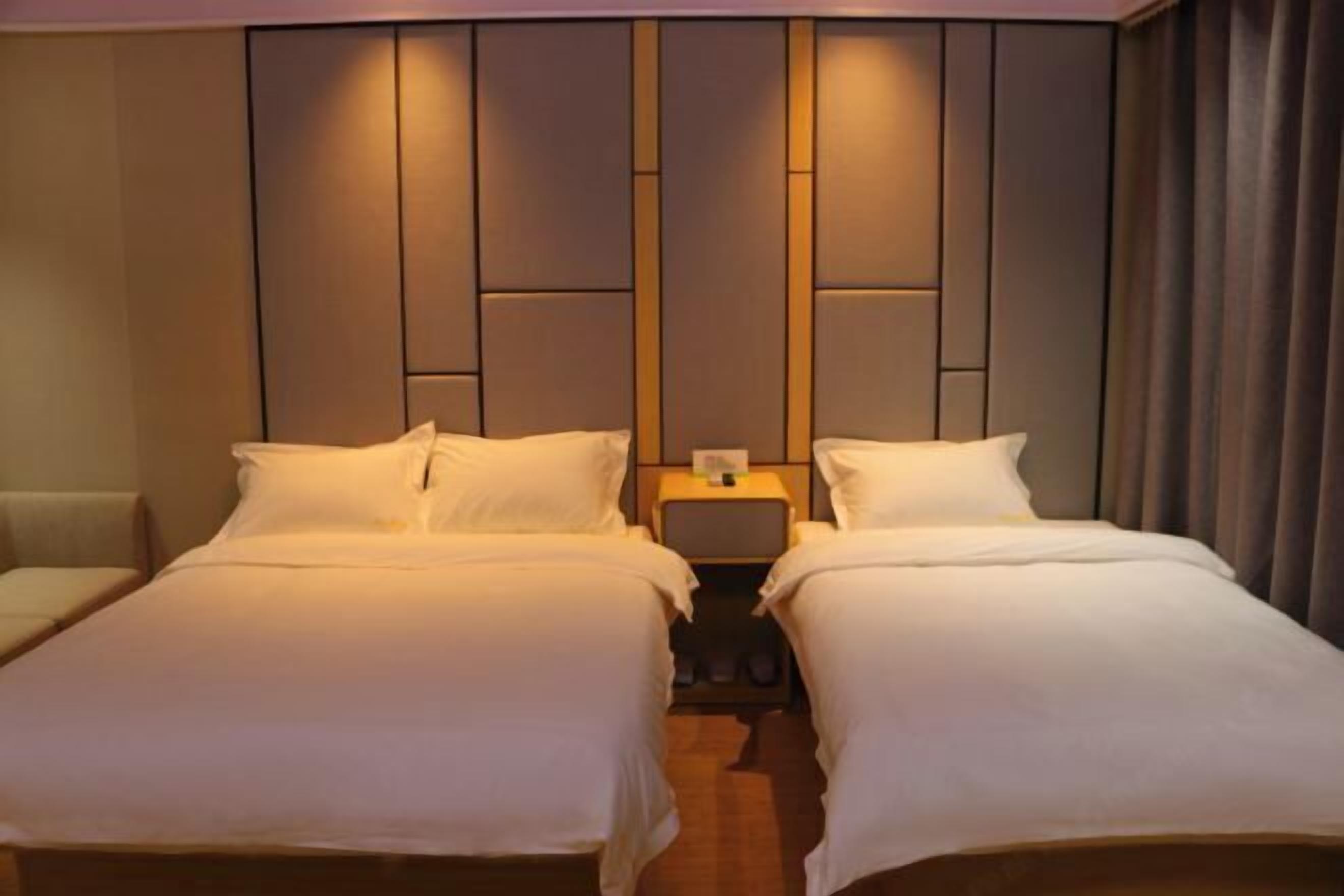 A double room with two beds, a nightstand between them, and a headboard with a vertical panel design.