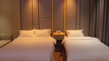 A double room with two beds, a nightstand between them, and a headboard with a vertical panel design.