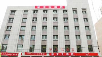 A multi-story hotel with a prominent red sign at the top.