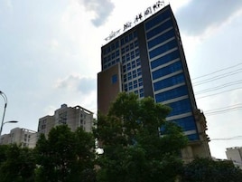 Un edificio moderno de varios pisos, con una entrada destacada y una serie de ventanas.