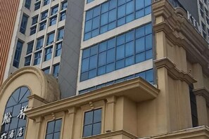 A building with a classical architectural style, featuring a prominent arched entrance and large windows. - Hanxiang International Hotel (Feidong)