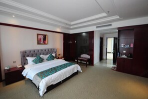 Una habitación de hotel con una cama grande, una mesita de noche, una silla, un escritorio y un armario.