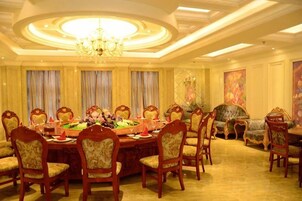 Un comedor formal con una mesa redonda, varias sillas y una araña.