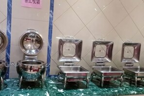 A row of metallic, reflective containers with lids, possibly for food or beverages, on a tiled floor. - Hanxiang International Hotel (Feidong)