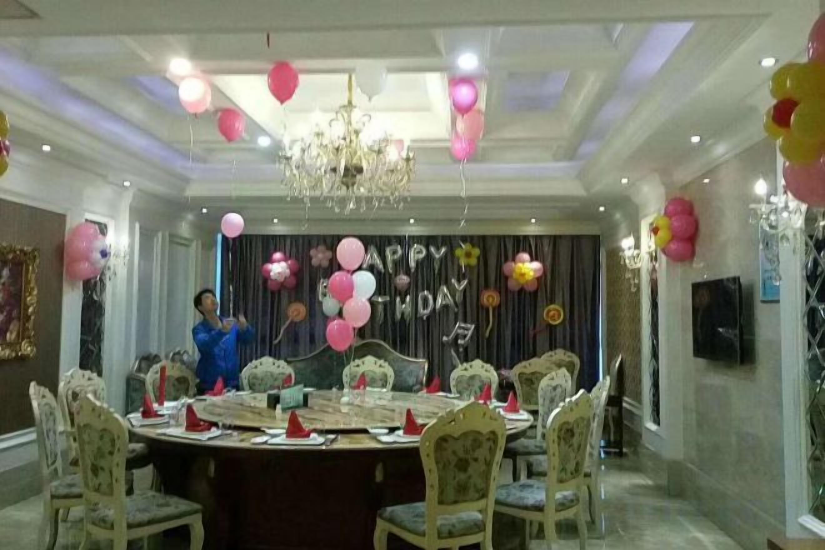 A formal dining room with a round table, chairs, and a chandelier.
