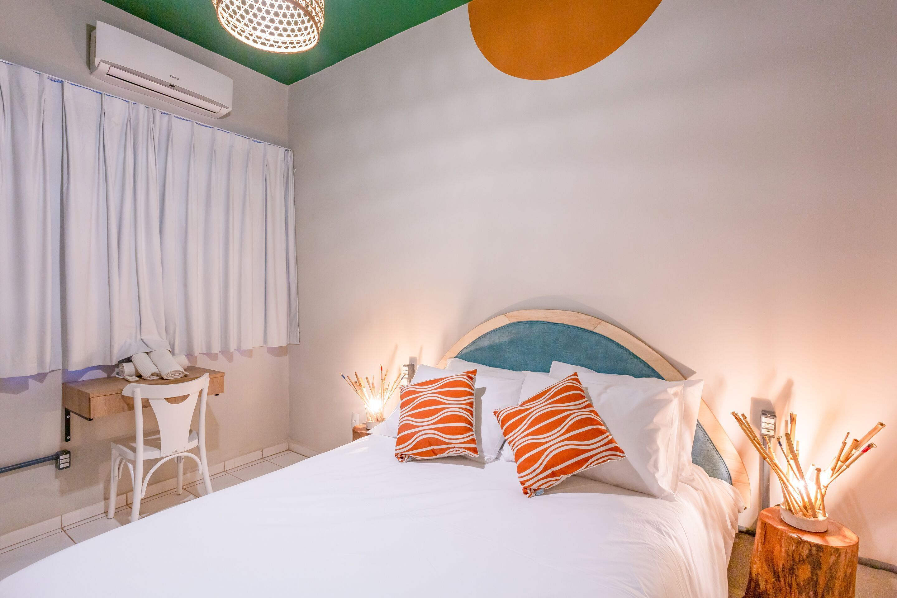 Une chambre bien rangée, avec un lit, une table de chevet, une chaise et un bureau avec une autre chaise.