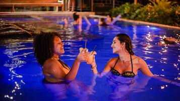 A swimming pool area with people enjoying the water.