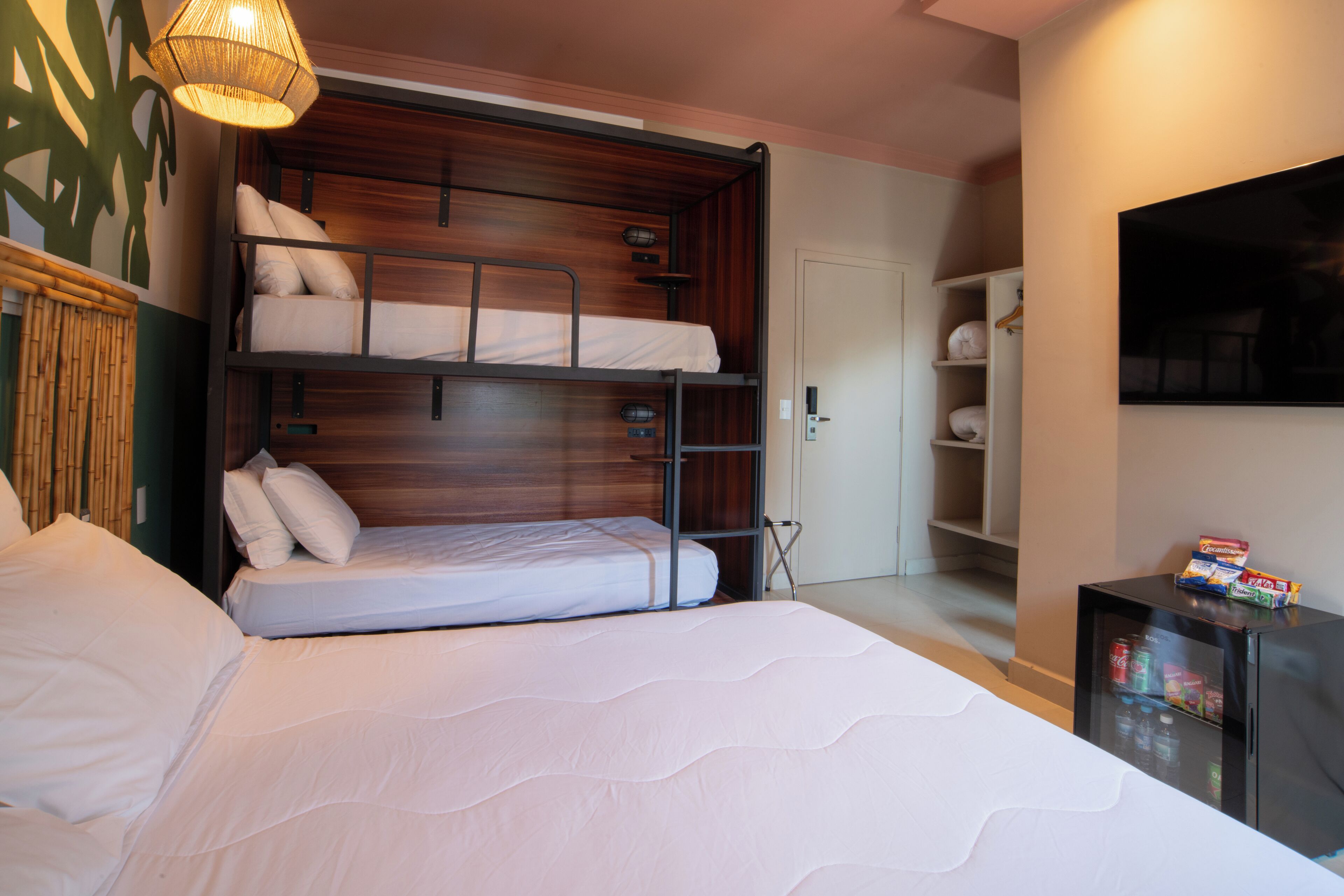 A bunk bed room with a television and a small cabinet.