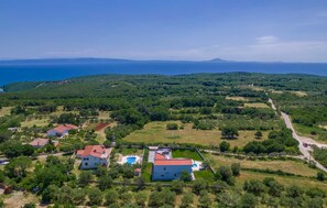 An aerial view of a residential area with houses, a swimming pool, and a road. - Luxury Villa Immensity with Pool (Krnica)