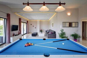 A modern living room with a pool table, a sofa, and a television. - Villa Luce del Sole with Pool (Krnica)