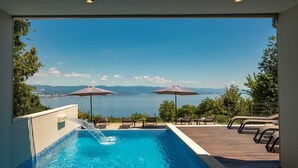Une piscine avec vue sur la ville et les montagnes.