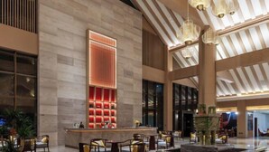 A spacious lobby with a high ceiling, modern lighting fixtures, and a central reception area with a red-lit panel. - Guangrong Hotel (Sanming)
