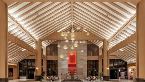 A spacious lobby with a high ceiling, modern chandeliers, and a central red accent wall. - Guangrong Hotel (Sanming)