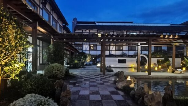 A traditional Japanese-style building with a covered walkway and a koi pond. - Guangrong Hotel (Sanming)