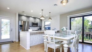 A modern kitchen with white cabinetry, stainless steel appliances, and a central island. - South Seas Beach House 22 (Captiva)