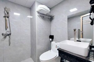 Un baño moderno con ducha, inodoro y lavamanos.