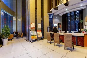 A hotel lobby with a reception desk, seating area, and a large potted plant. - Jilong Hotel (Longli County Traditional Chinese Medicine Hospital) (Longli)