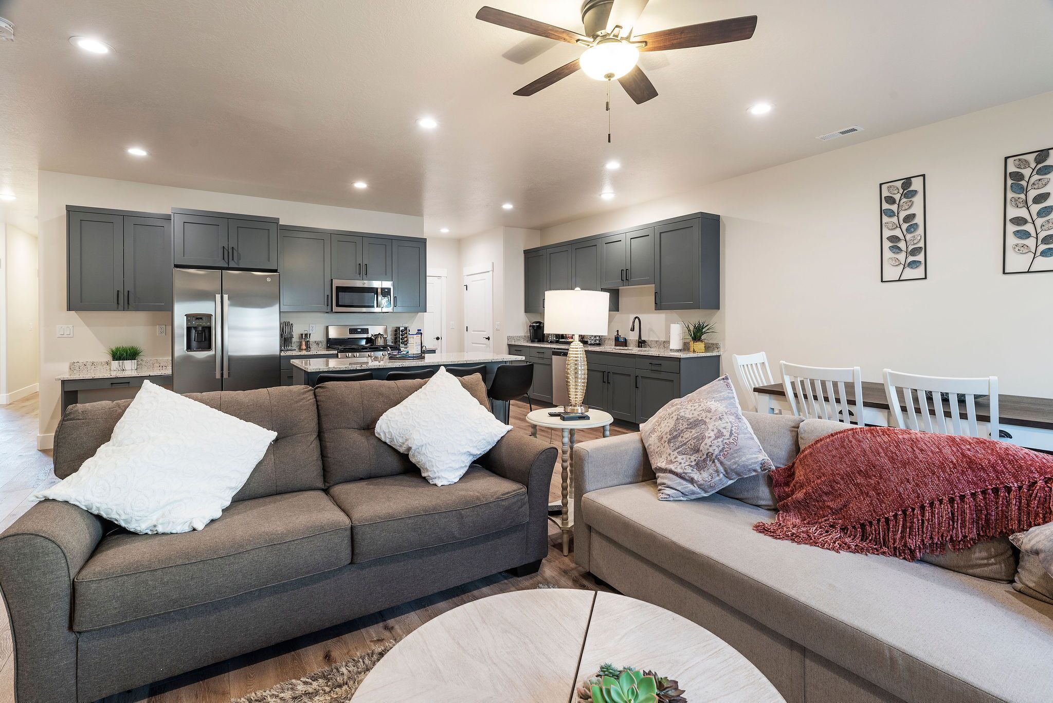 A modern living room with a grey sofa, a coffee table, and a red blanket.