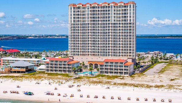 Een hoog hotel met meerdere balkons, een ligging aan het strand en uitzicht op de oceaan.