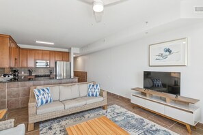 A modern living room with a sofa, TV, and wooden coffee table.